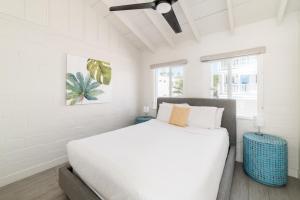 a white bedroom with a bed and a ceiling fan at Pacific Villas in Oceanside