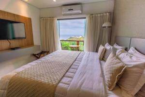 a bedroom with a large bed with a large window at Miragem Noronha in Fernando de Noronha