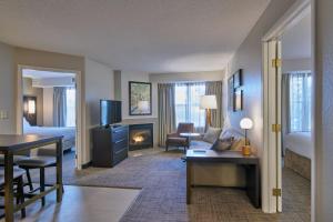 a hotel suite with a living room with a fireplace at Residence Inn by Marriott Detroit / Novi in Novi