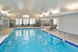 a swimming pool with blue water in a building at Residence Inn by Marriott Detroit / Novi in Novi