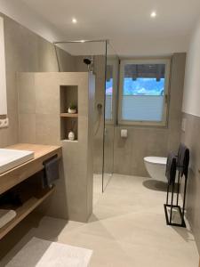 ein Bad mit einer Dusche, einem Waschbecken und einem WC in der Unterkunft Ferienwohnung Eichnerhof in Margreid an der Weinstraße