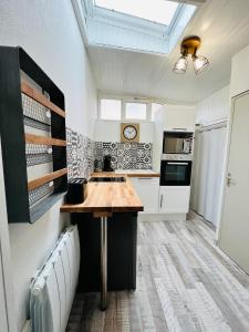 a kitchen with a wooden counter in a room at L’escale proche centre ville in Amiens +12 photos