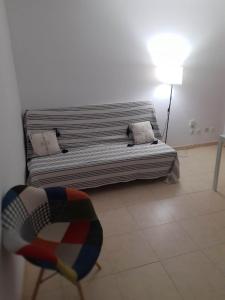 uma sala de estar com um sofá e um candeeiro em Apartament Maia Ocean em Corralejo