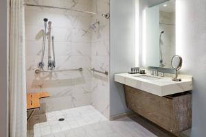 a bathroom with a sink and a shower at HOTEL PASEO, Autograph Collection in Palm Desert