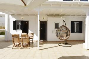 a patio with a table and chairs and a swing at Aspasia's Fresh House in Adamas