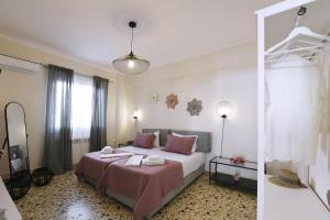 a bedroom with a large bed with pink pillows at Aspasia's Fresh House in Adamas