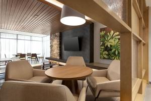 a waiting room with chairs and a table and a tv at Fairfield by Marriott Inn & Suites Bonita Springs in Bonita Springs