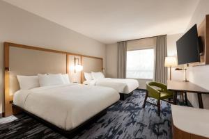 a hotel room with two beds and a television at Fairfield by Marriott Inn & Suites Bonita Springs in Bonita Springs