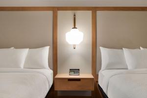 a hotel room with two beds and a clock on a night stand at Fairfield by Marriott Inn & Suites Bonita Springs in Bonita Springs