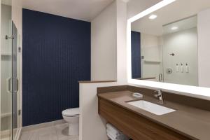 a bathroom with a sink and a mirror and a toilet at Fairfield by Marriott Inn & Suites Bonita Springs in Bonita Springs