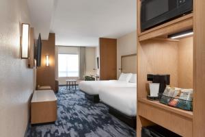 a hotel room with two beds and a flat screen tv at Fairfield by Marriott Inn & Suites Bonita Springs in Bonita Springs