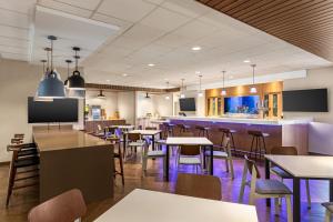 a restaurant with tables and chairs and a bar at Fairfield by Marriott Inn & Suites Bonita Springs in Bonita Springs