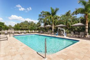 博尼塔溫泉的住宿－Fairfield by Marriott Inn & Suites Bonita Springs，度假村的游泳池,配有椅子和遮阳伞