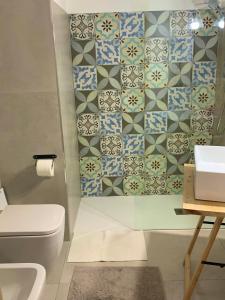 a bathroom with a toilet and a sink and tiles at Casa con piscina e vista mare dal giardino in Fanusa +38 photos