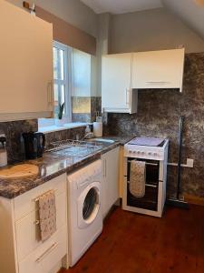 a kitchen with a washing machine and a washer at Boston House- Historic house situated in beautiful market town in Duns