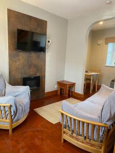 a living room with two chairs and a fireplace at Boston House- Historic house situated in beautiful market town in Duns