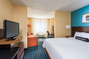 Fairfield Inn & Suites Grand Rapids في غراند رابيدز: غرفة فندقية بسرير وتلفزيون بشاشة مسطحة