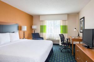 a hotel room with a bed and a flat screen tv at Fairfield Inn & Suites Grand Rapids in Grand Rapids