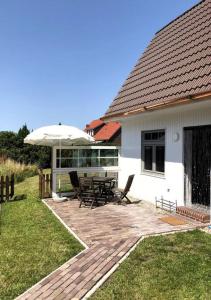 諾登的住宿－"Kleine 4" Idyllisches TinyHouse an der Nordsee，庭院配有遮阳伞和桌椅。