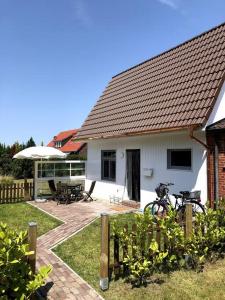 une maison avec une terrasse et un vélo garé devant elle dans l'établissement "Kleine 4" Idyllisches TinyHouse an der Nordsee, à Norden
