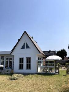 una casa blanca con una mesa de picnic delante de ella en "Kleine 4" Idyllisches TinyHouse an der Nordsee en Norden