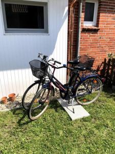 two bikes parked in the grass next to a house at "Kleine 4" Idyllisches TinyHouse an der Nordsee in Norden