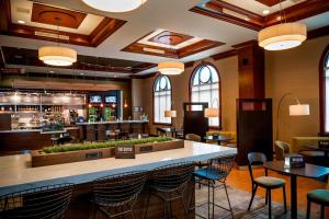 un restaurante con un bar con mesas y sillas en Courtyard by Marriott Norfolk Downtown en Norfolk