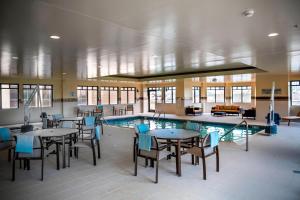 a pool room with tables and chairs and a swimming pool at Courtyard by Marriott Norfolk Downtown in Norfolk