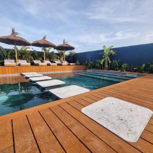 una piscina con terraza de madera y suelo de madera en The Salty Pelican Yoga & Surf Retreat en Peniche