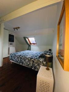 a bedroom with a bed and a lamp on a table at L’escale proche centre ville in Amiens