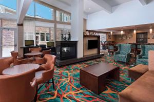 a hotel lobby with couches and chairs and a fireplace at Residence Inn by Marriott Omaha West in Omaha