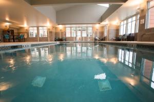 a large swimming pool with blue water in a building at Residence Inn by Marriott Omaha West in Omaha