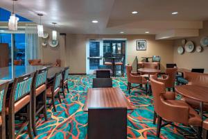 um restaurante com mesas e cadeiras e um bar em Residence Inn by Marriott Omaha West em Omaha