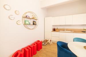una cucina con sedie rosse e un cane seduto sul pavimento di Mizzica! - Holiday Home a Taormina