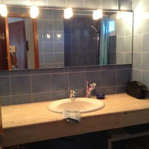 La salle de bains est pourvue d'un lavabo et d'un miroir. dans l'établissement Klein cosy appartement met frontaal strand en zeezicht Las Damas, à Benidorm