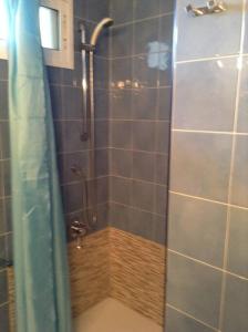 La salle de bains est pourvue d'une douche avec une porte en verre. dans l'établissement Klein cosy appartement met frontaal strand en zeezicht Las Damas, à Benidorm
