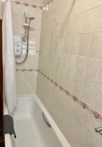 a bathroom with a bath tub and a shower at Ocean View in Ilfracombe +14 photos