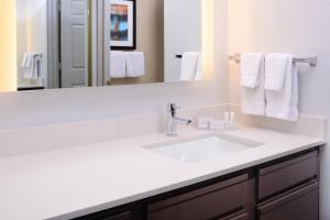 a bathroom with a white sink and a mirror at Residence Inn by Marriott Dallas Plano/Legacy in Plano +13 photos