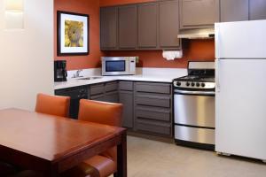 a kitchen with a white refrigerator and a table at Residence Inn by Marriott Dallas Plano/Legacy in Plano