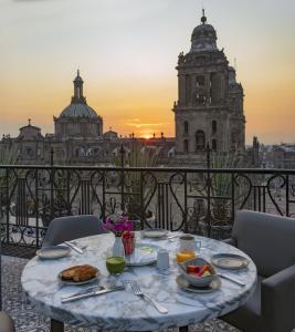 una mesa con comida en ella con vistas a un edificio en Zocalo Central & Rooftop Mexico City, en Ciudad de México