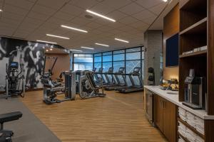 un gimnasio con una fila de cintas de correr y máquinas en Wichita Marriott en Wichita