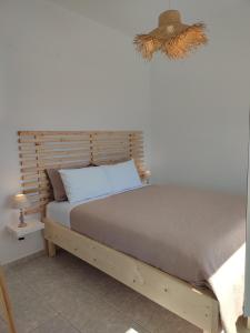 1 dormitorio con 1 cama con cabecero de madera en Sofia sea view apartment en Fáros