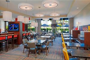 a dining room with tables and chairs and windows at Residence Inn by Marriott Los Angeles LAX/Century Boulevard in Los Angeles