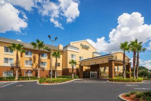 a hotel with palm trees in front of a parking lot at Fairfield Inn & Suites by Marriott Clermont in Clermont