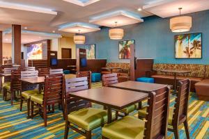 a restaurant with tables and chairs and a couch at Fairfield Inn & Suites by Marriott San Diego Carlsbad in Carlsbad