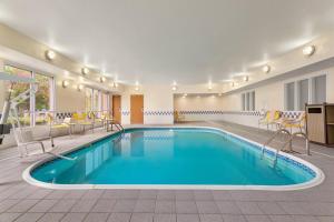 a pool in a hotel room with chairs and tables at Fairfield Inn & Suites by Marriott Norman in Norman
