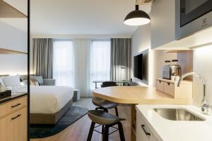 une chambre d'hôtel avec un lit et une cuisine dans l'établissement Residence Inn by Marriott Dortmund City, à Dortmund