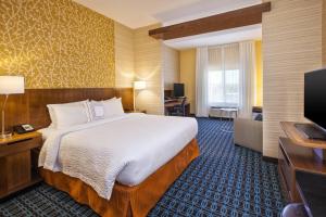 a hotel room with a bed and a flat screen tv at Fairfield Inn & Suites by Marriott Plattsburgh in Plattsburgh