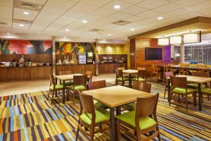 a dining room with tables and chairs and a tv at Fairfield Inn & Suites by Marriott Plattsburgh in Plattsburgh