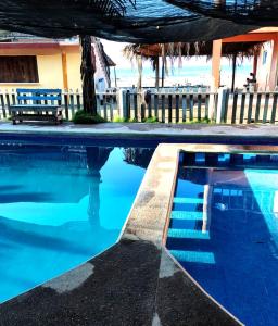 a swimming pool in front of a house with blue water at Nexpa cabañas Martha surf spot in Caleta de Campos